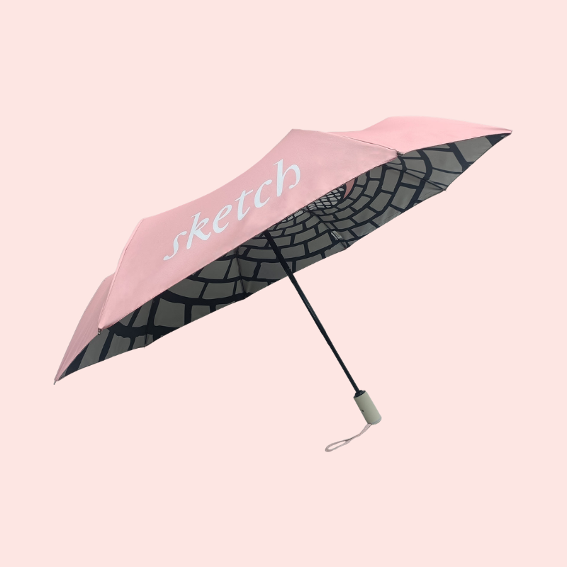 Load image into Gallery viewer, Pink umbrella with black pattern and 'sketch' branding on a white background